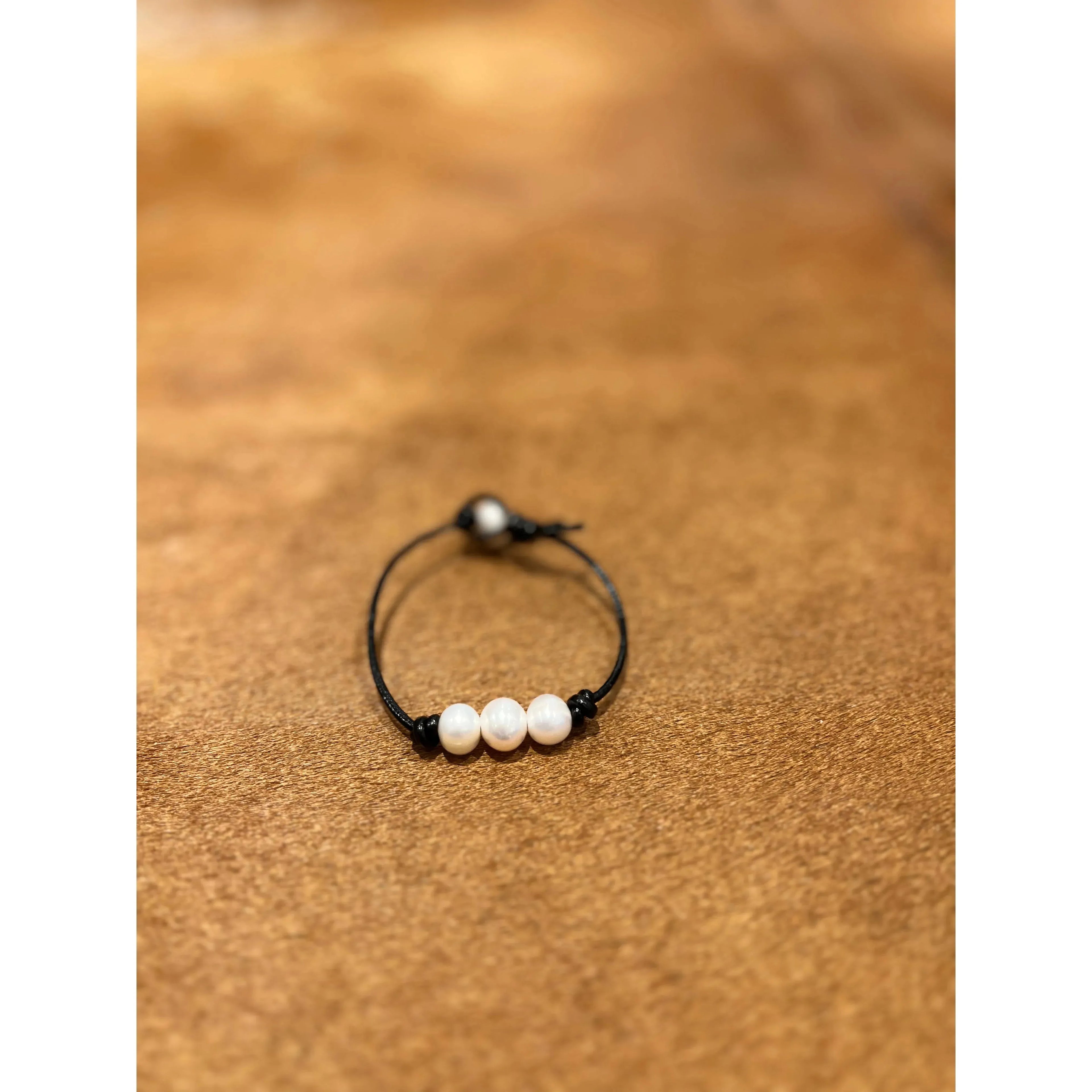 Pearls on black leather bracelet