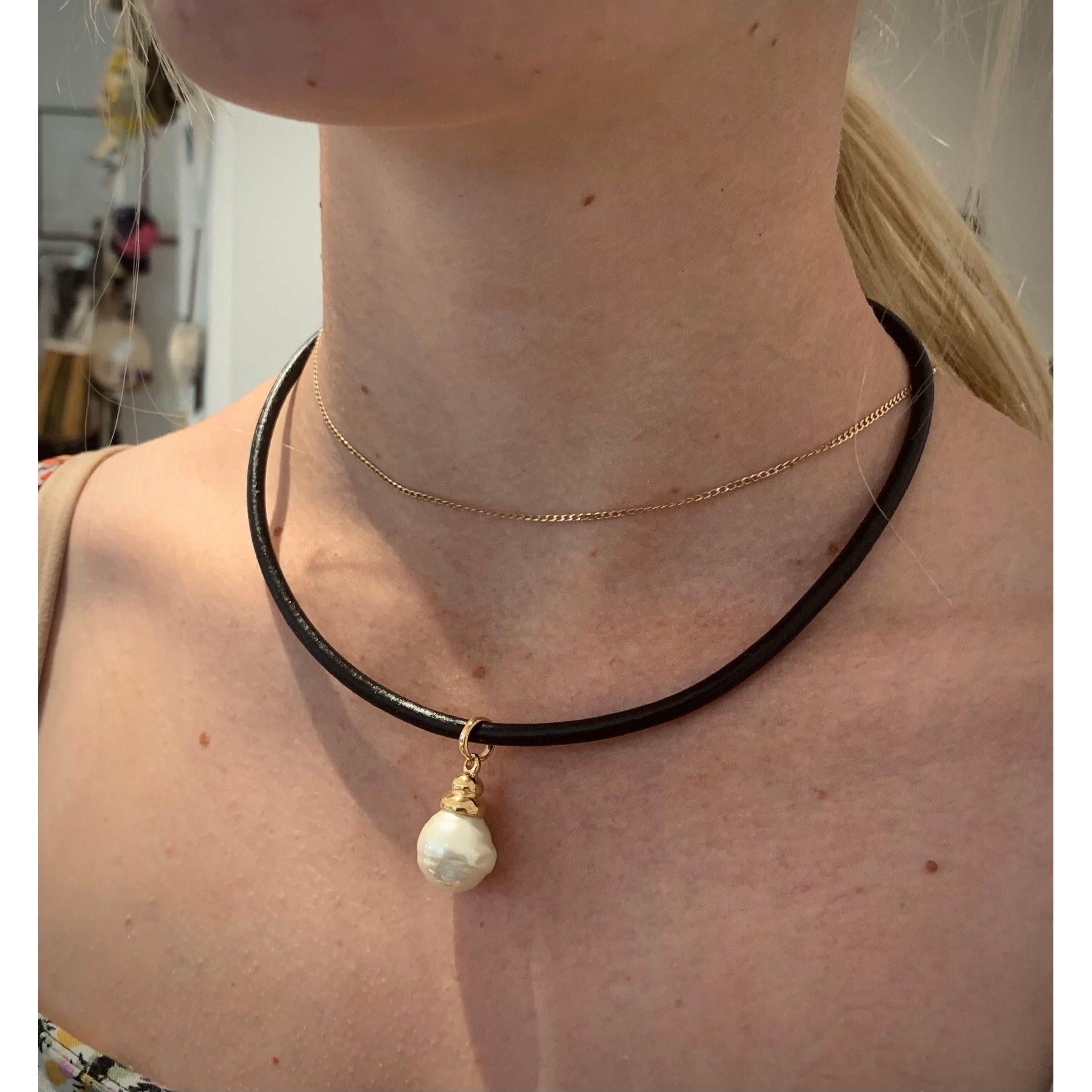 Spanish Pearl displayed on thick leather cord necklace with gold detail